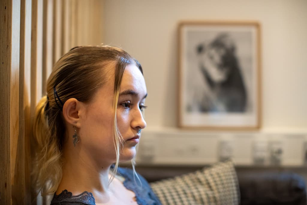Pige der sidder og kigger ud i luften